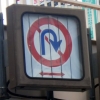 写真3　横断歩道橋に共架された道路の規制標識（左、Uターン禁止）と指示標識（右、中央線）